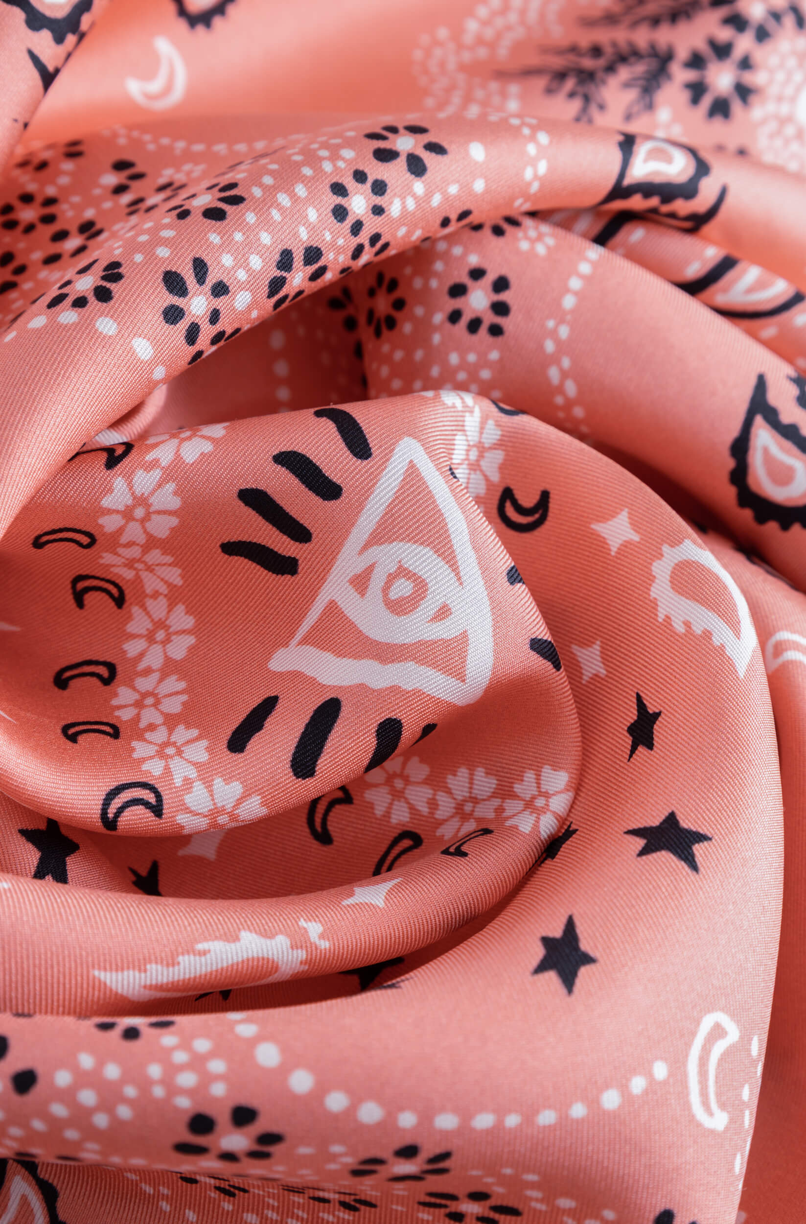 Detail with texture of the coral silk scarf with bandana pattern