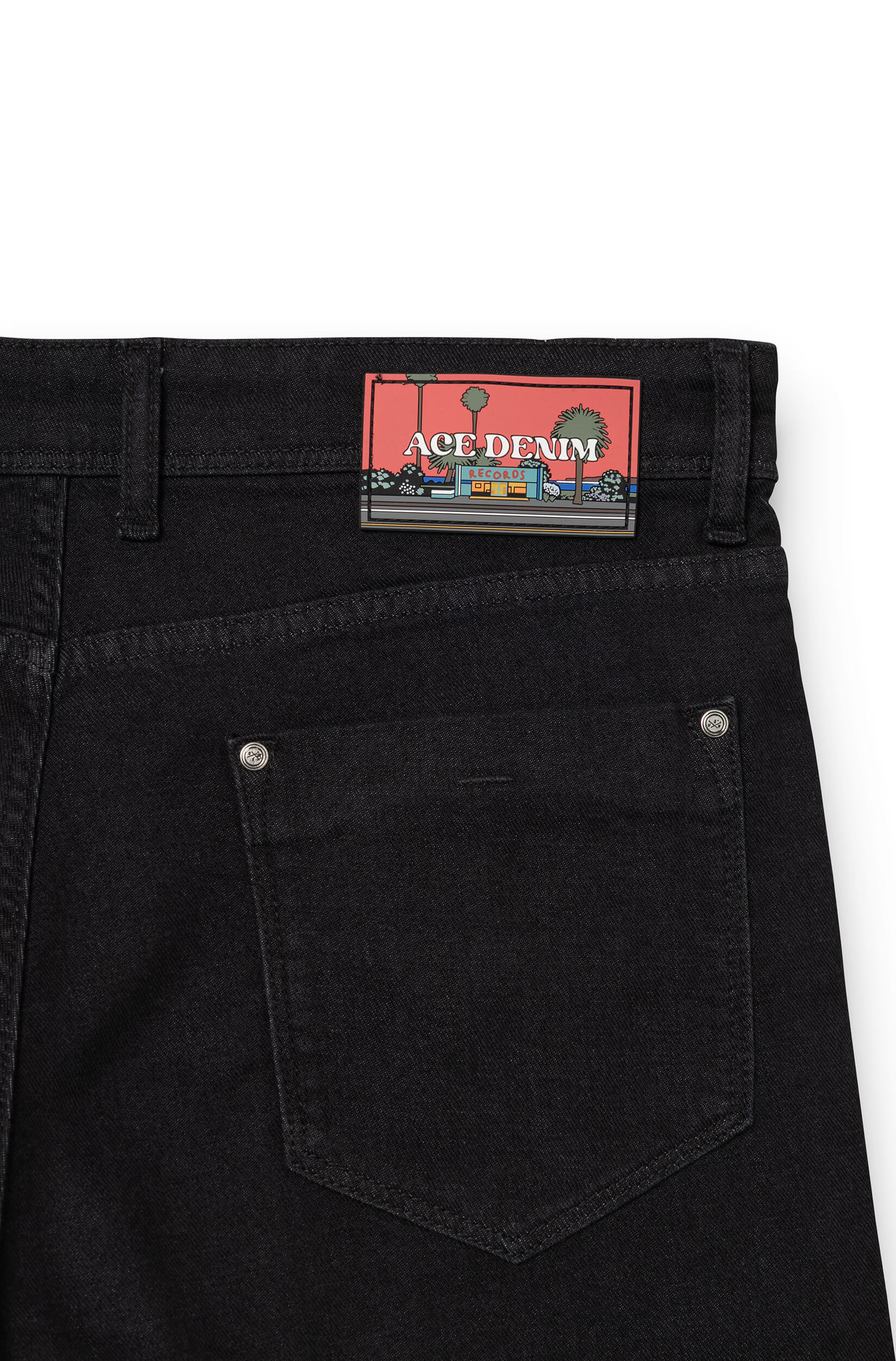 Detail of silicone signature patch on back waistband of black AD 33 — Ace Denim Paris