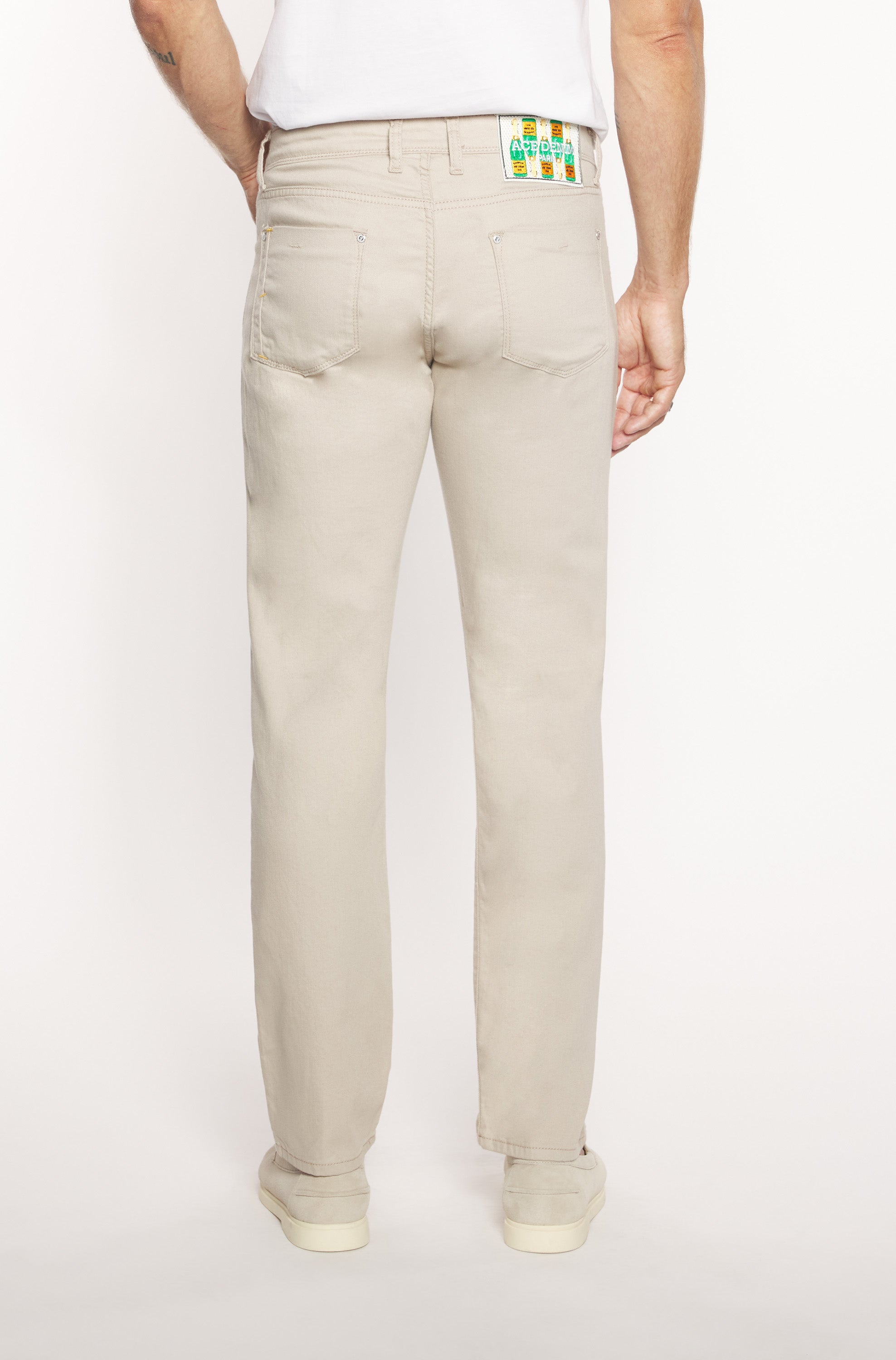 Dos du mannequin portant le jeans slim en coton et lin beige pour homme