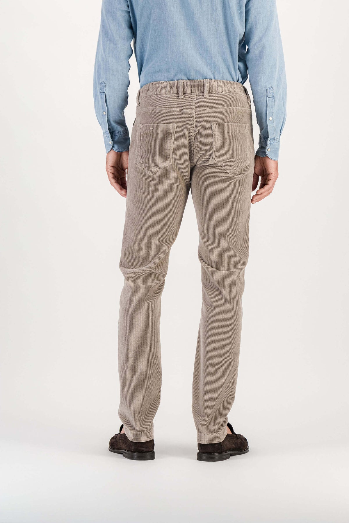 Full-length back view, ash grey corduroy trousers, blue denim shirt, brown loafers, model 186 cm size 32 — Ace Denim Paris
