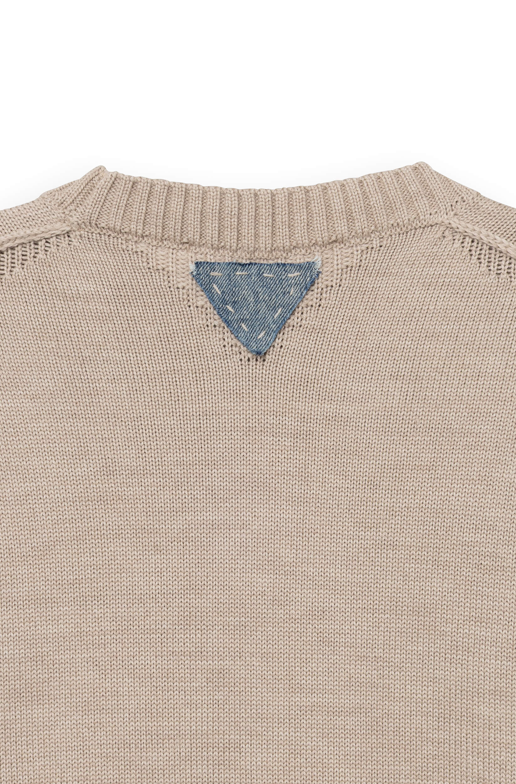 Detail of the blue denim triangle sewn onto the collar