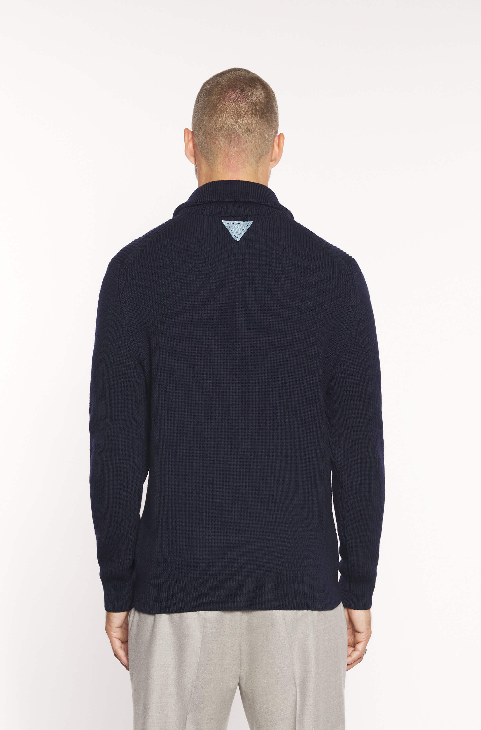 Rear view of the model wearing the navy zip-neck sweater
