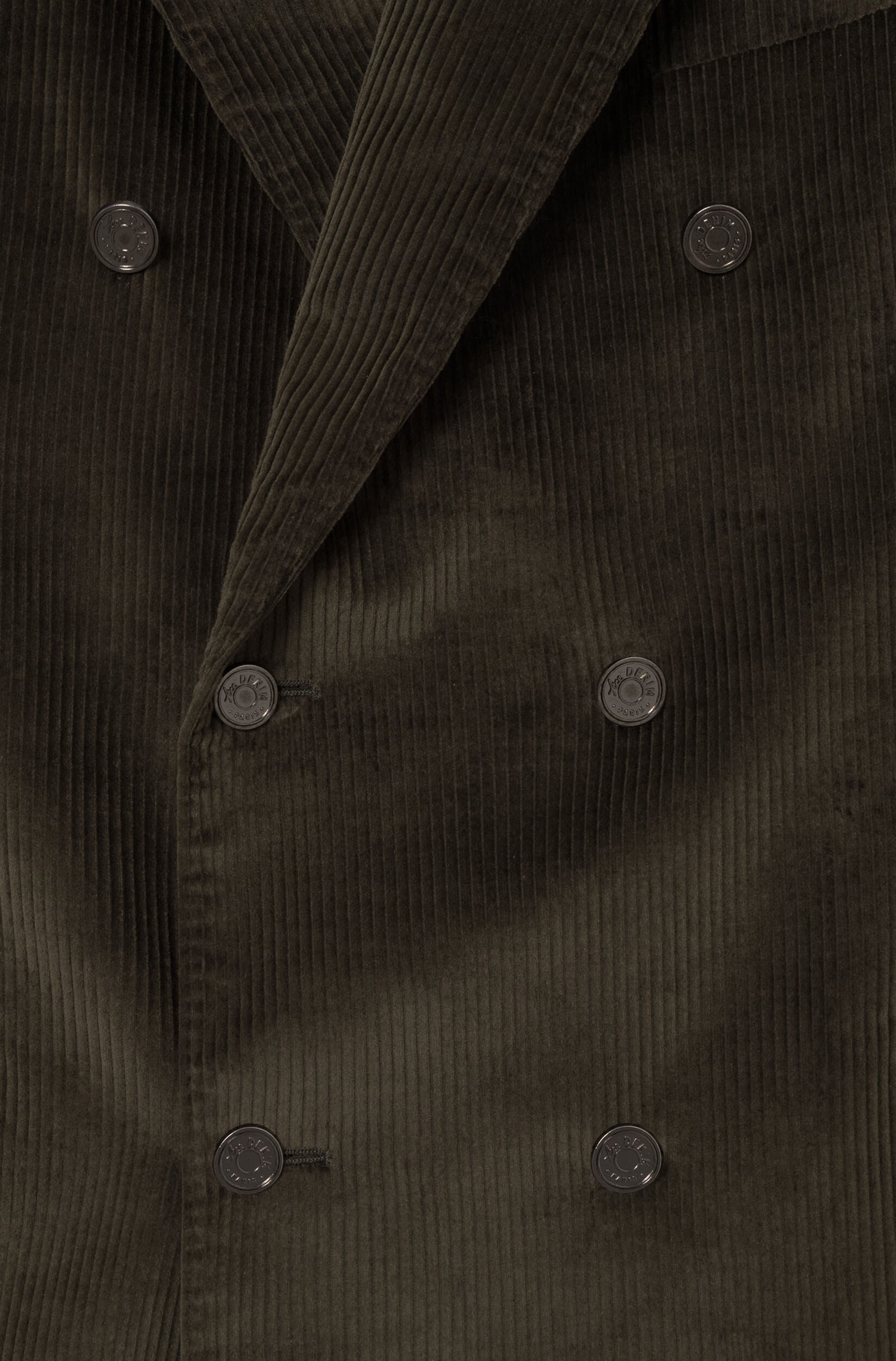 Detail of the metal buttons on the crossed jacket in khaki velvet