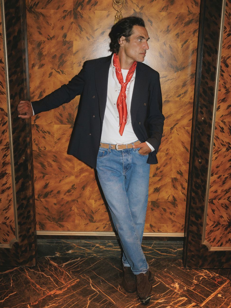 Mannequin portant le jeans en selvedge bleu clair avec la ceinture cowboy cognac, le t-shirt life, la chemise de smoking blanche, le foulard ketchup rouge et la veste en laine froide marine