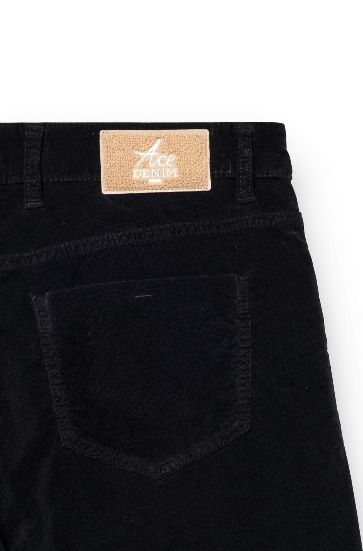Focus on the beige embroidered patch on the back of the trousers