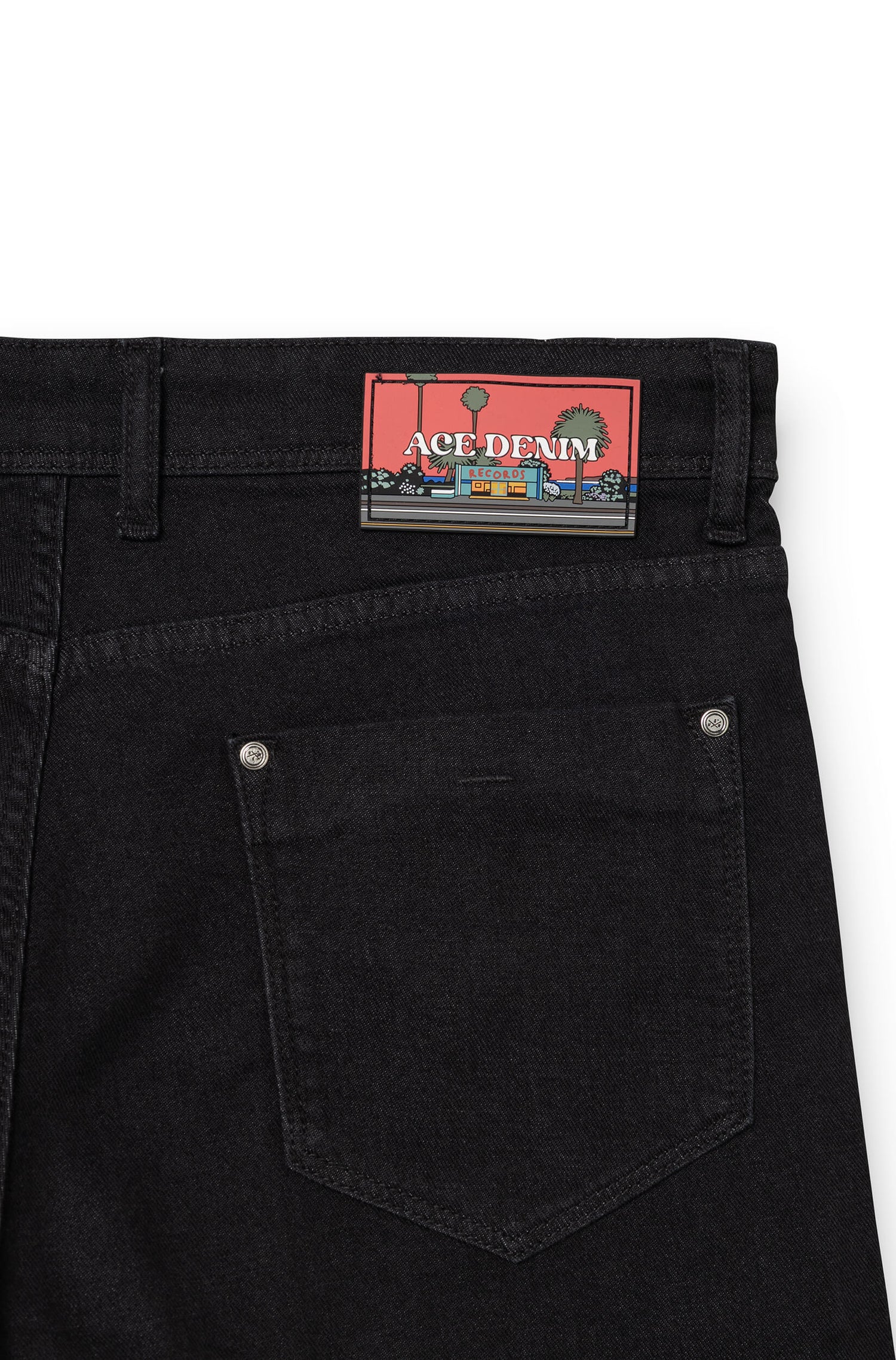 Detail of silicone signature patch on back waistband of black AD 33 — Ace Denim Paris