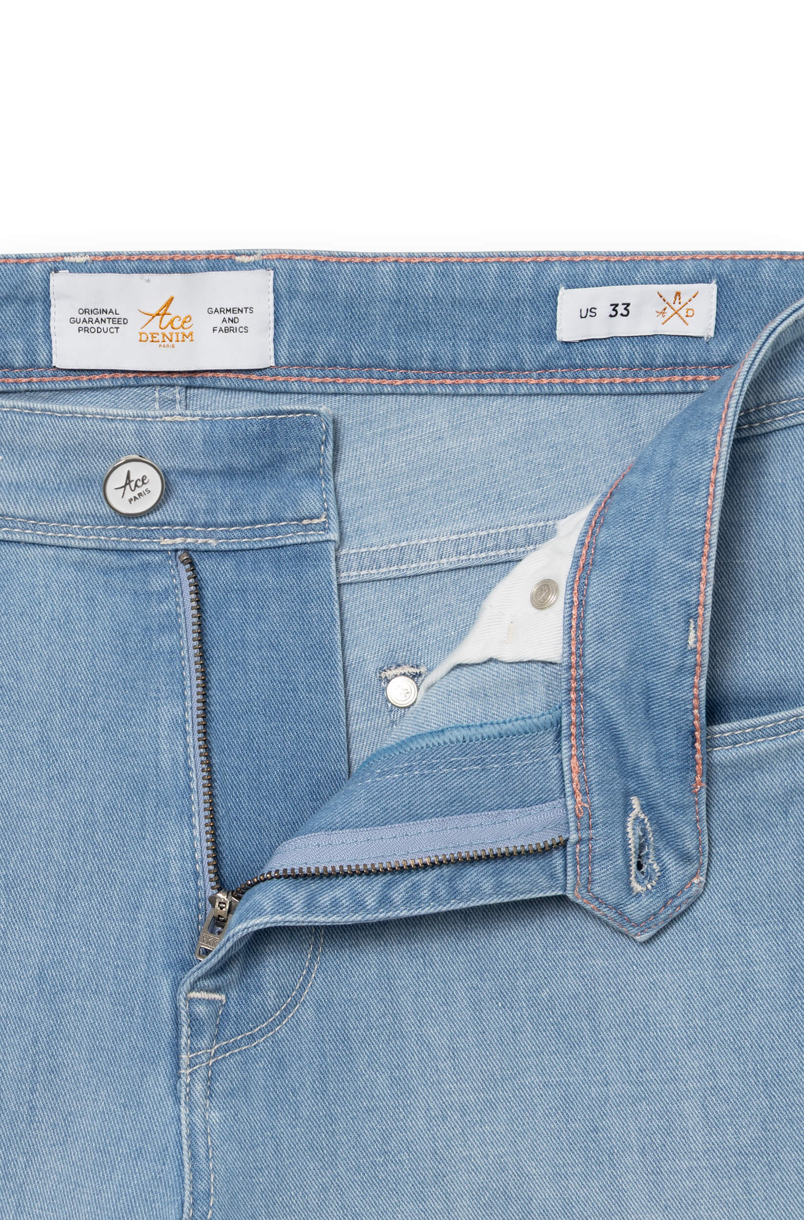Détail de la braguette zip et du bouton laqué logo gravé Ace Paris, surpiqûres orangées — jean AD 33 Ace Denim Paris
