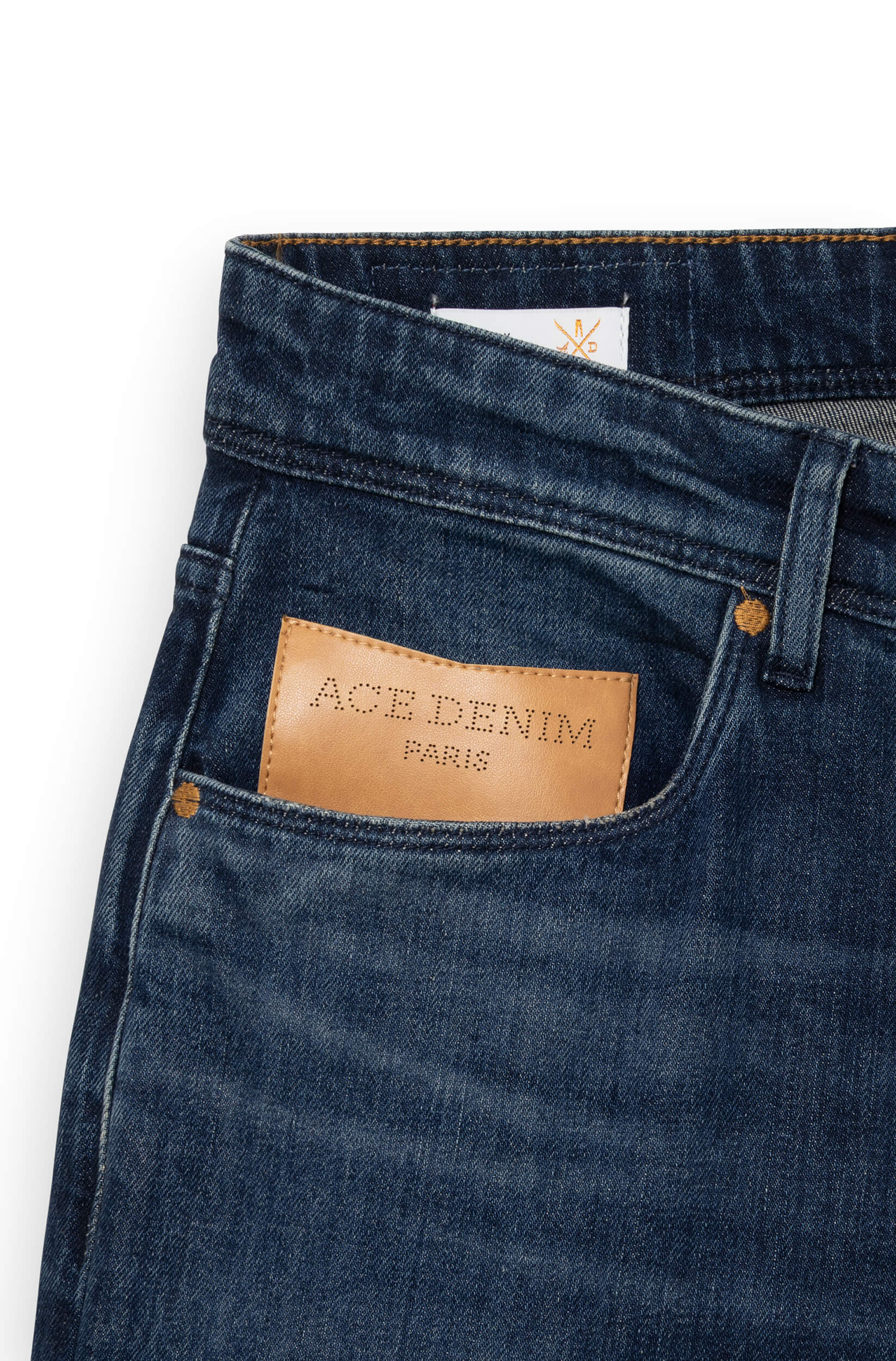 Detail of the beige patch on the front of the dark blue jeans AD03
