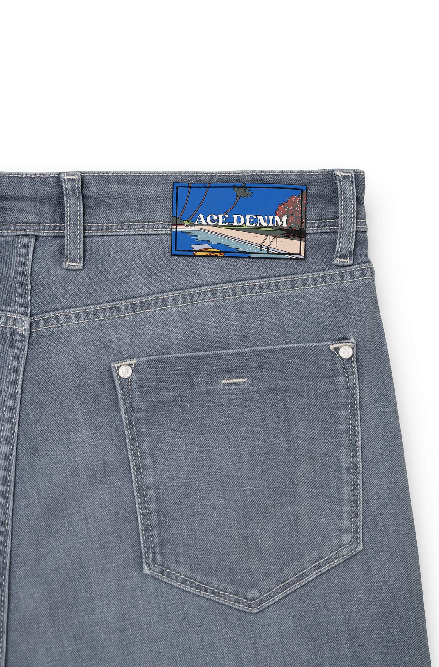 Detail of silicone signature patch on back waistband of light grey AD 33 — Ace Denim Paris