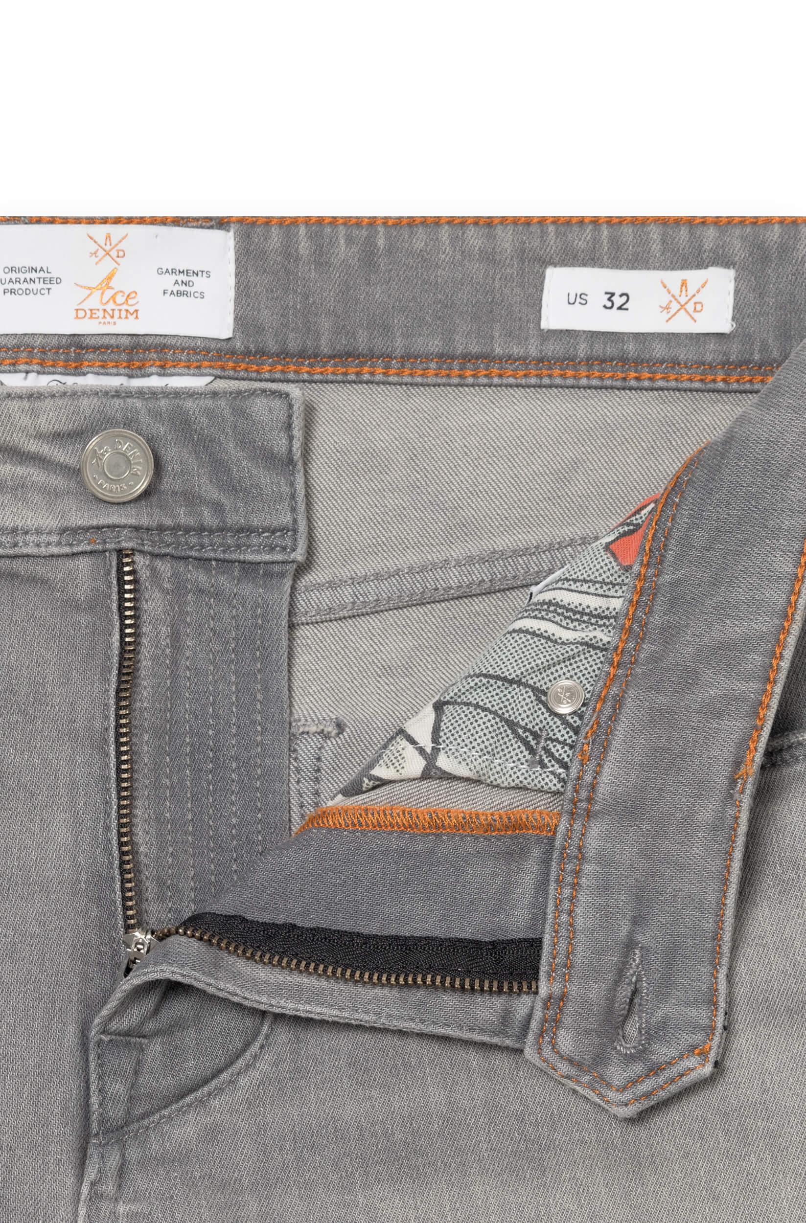Détail de la braguette et du bouton en métal du jeans gris en cachemire