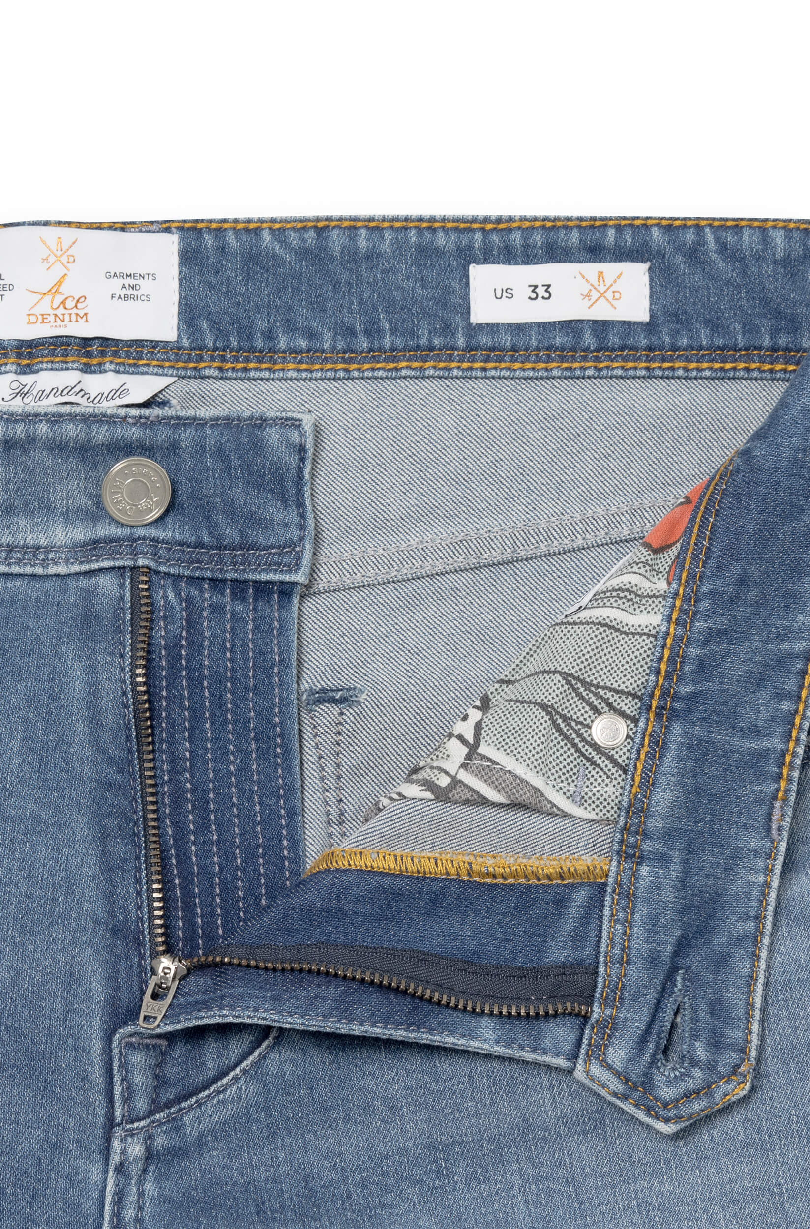 Detail of the fly and the metal button of the light blue jeans