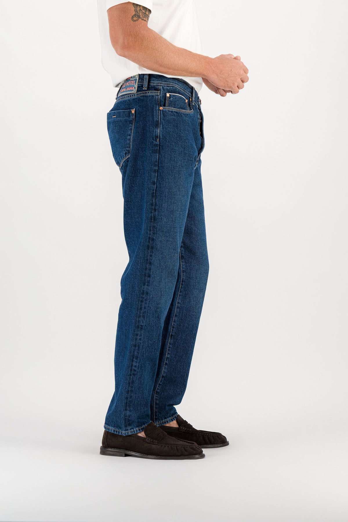 Jean droit selvedge dark stone vue de côté, patch brodé signature visible en ceinture — AD 53 Selvedge Ace Denim Paris