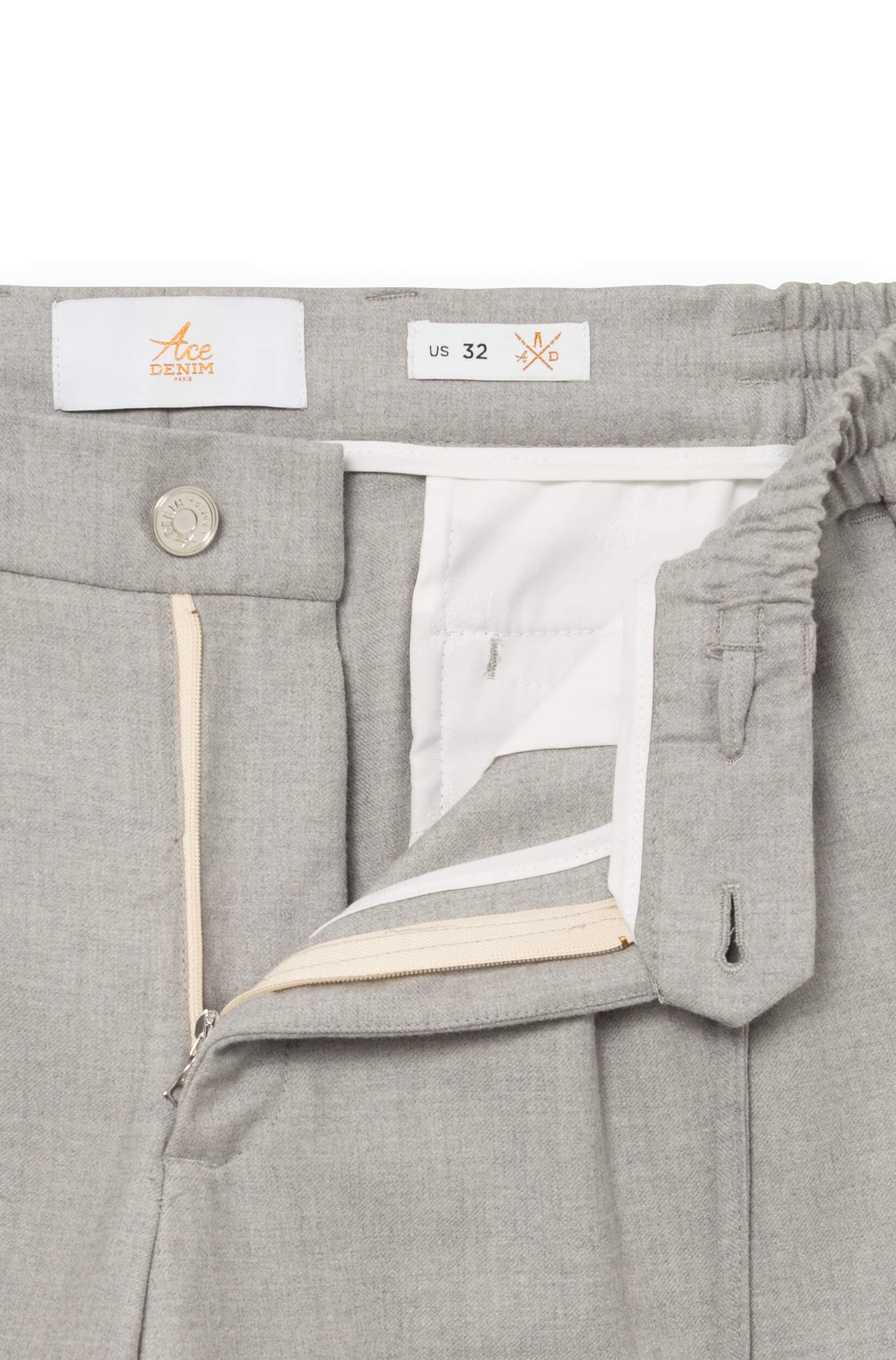 Detail of the front of the light gray trousers with metal button and fly