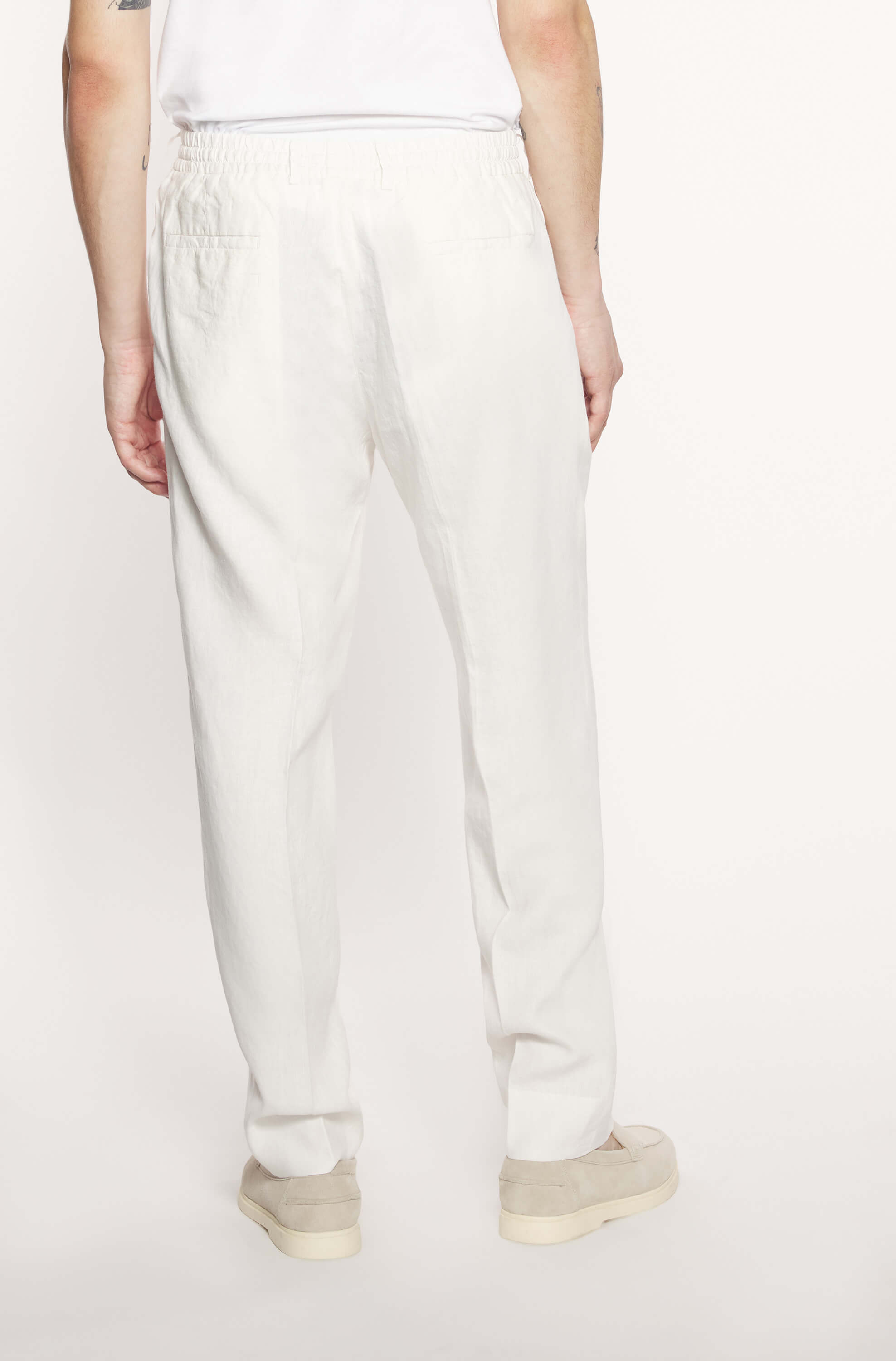 Dos du mannequin portant le pantalon jogging en lin blanc
