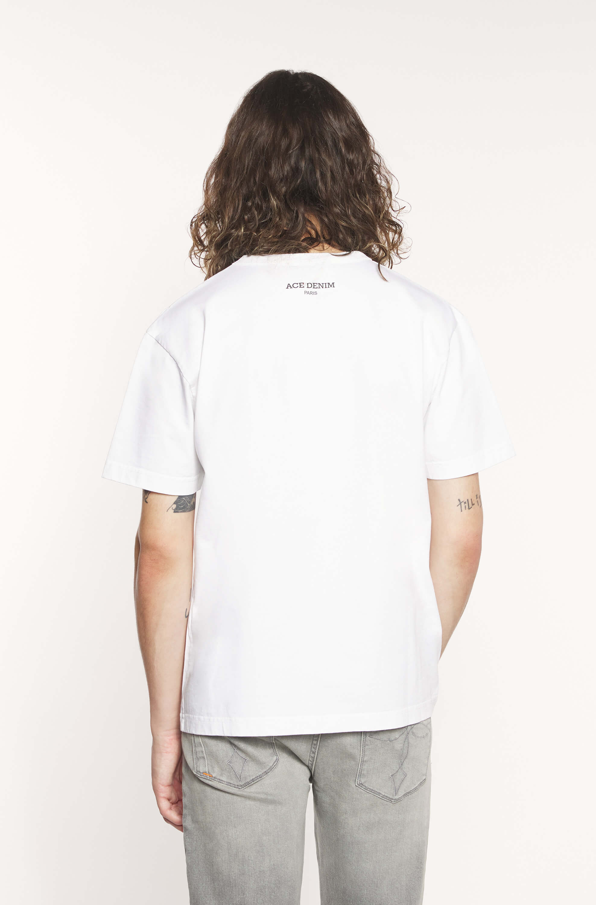 Back of the model wearing the white t-shirt with black "breaking i don&
