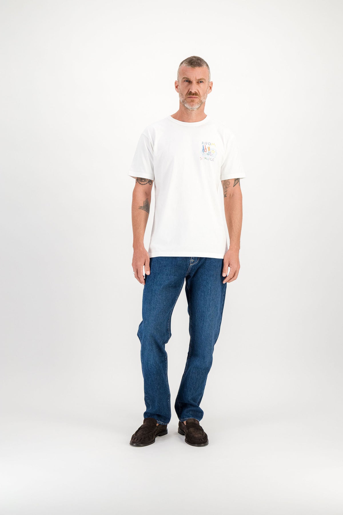 T-shirt Room Service Blanc porté de face, illustration Room Service sur la poitrine, mannequin 1m86 taille M — Ace Denim Paris