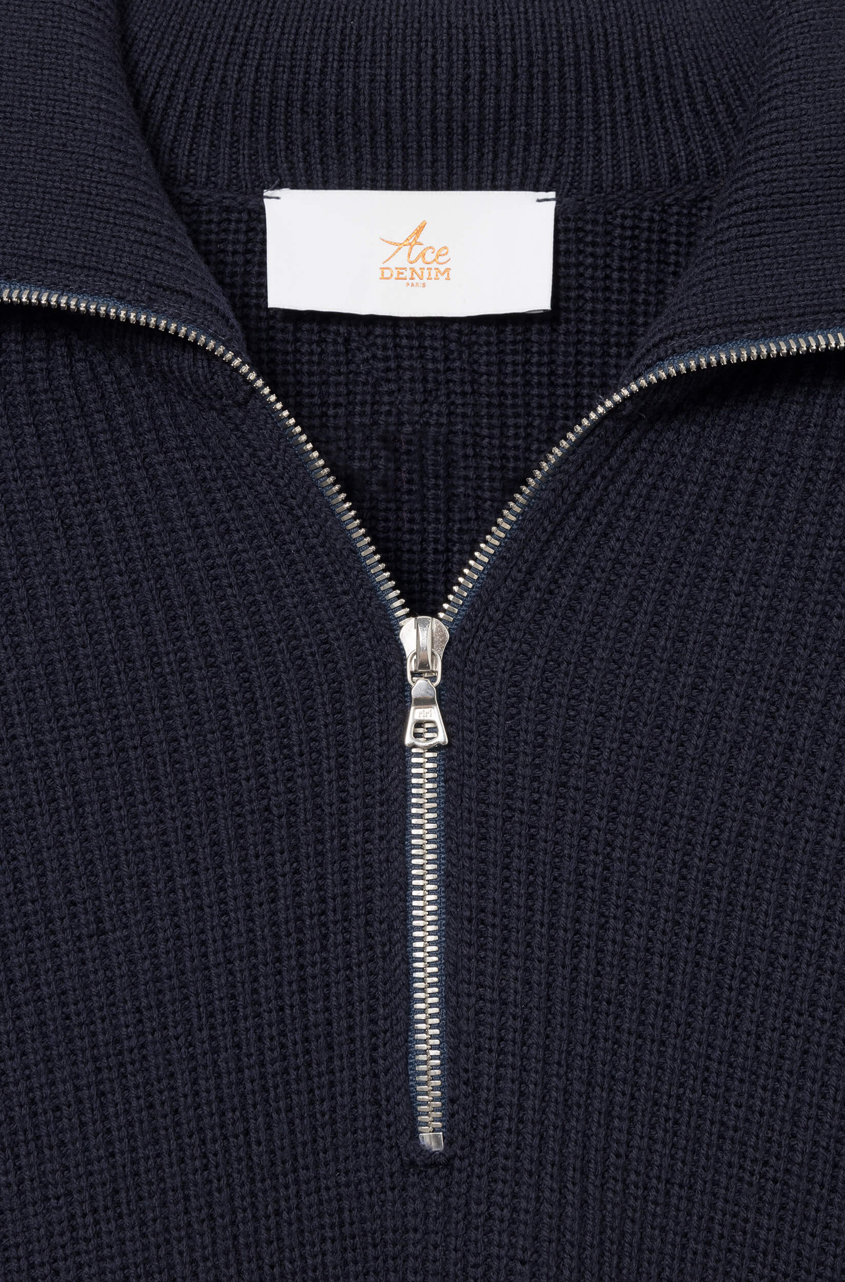 Detail of the RiRi zipper of the navy sweater