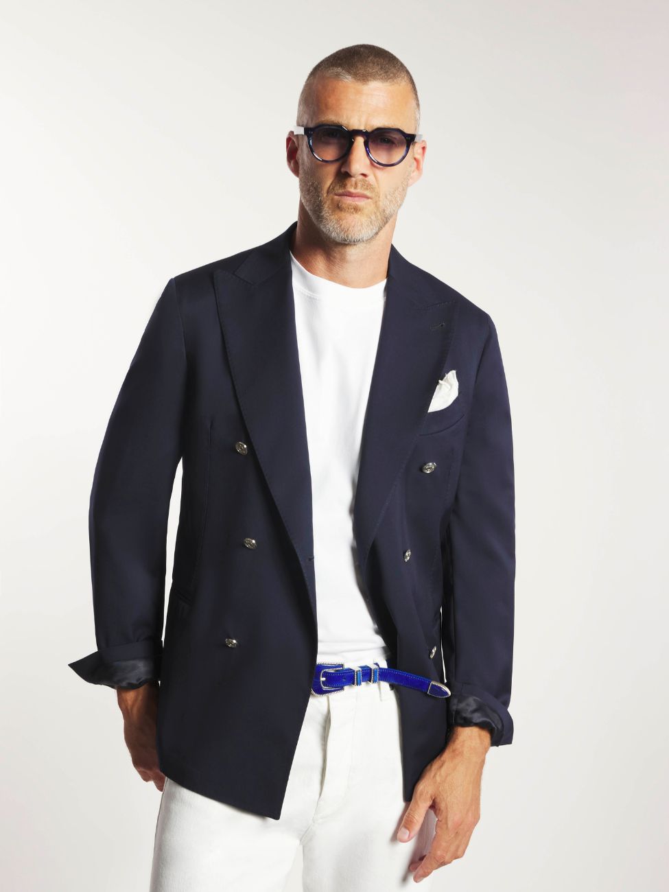 Mannequin portant une veste en laine froide marine avec un jeans blanc et une ceinture bleu roi